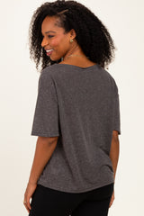 woman wearing a loose-fitting charcoal gray short sleeve t-shirt, smiling and facing sideways