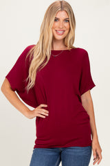 woman wearing a burgundy oversized tee with short sleeves and a relaxed fit, paired with blue jeans