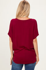 woman wearing a burgundy short sleeve top with a relaxed fit and scoop neckline, viewed from the back
