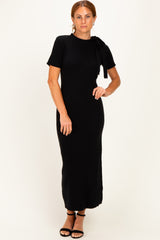 woman wearing a black ribbed knit maxi dress with short sleeves and a bow detail on the shoulder