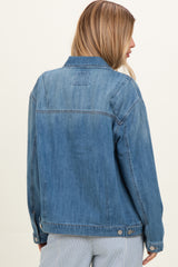 woman wearing a light blue denim jacket, viewed from the back, with a relaxed fit and classic style details