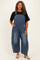 woman wearing a black oversized t-shirt and blue denim plus size overalls with wide legs