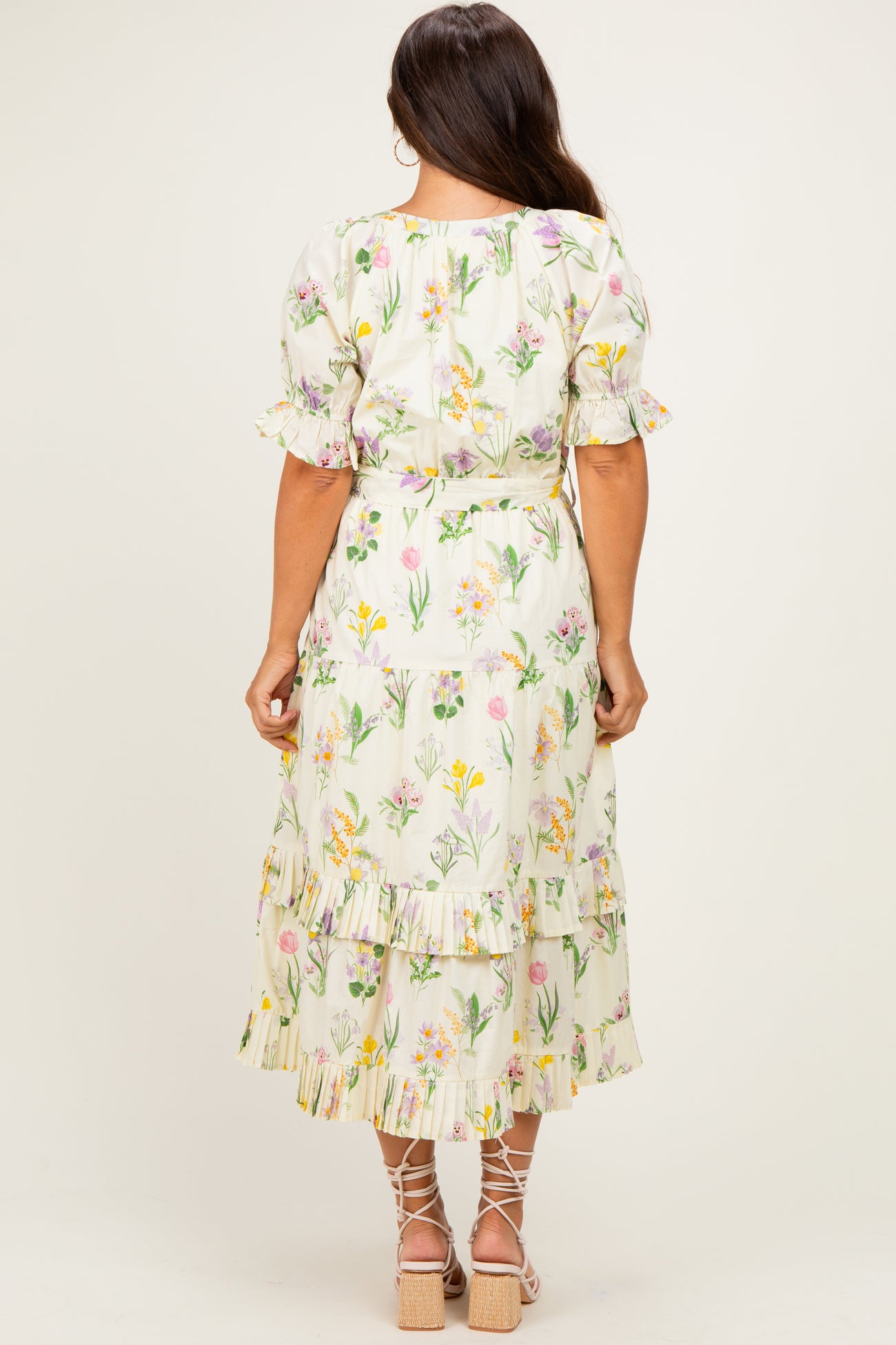 woman wearing a floral printed maternity dress with ruffled tiers and short sleeves, showing her baby bump