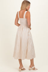 woman wearing a beige and white striped midi dress with a smocked bodice and adjustable straps, viewed from the back