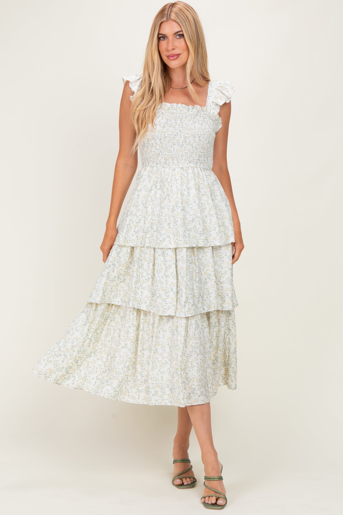 woman wearing a light floral print maxi dress with ruffled sleeves and tiered skirt