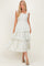woman wearing a light floral print maxi dress with ruffled sleeves and tiered skirt