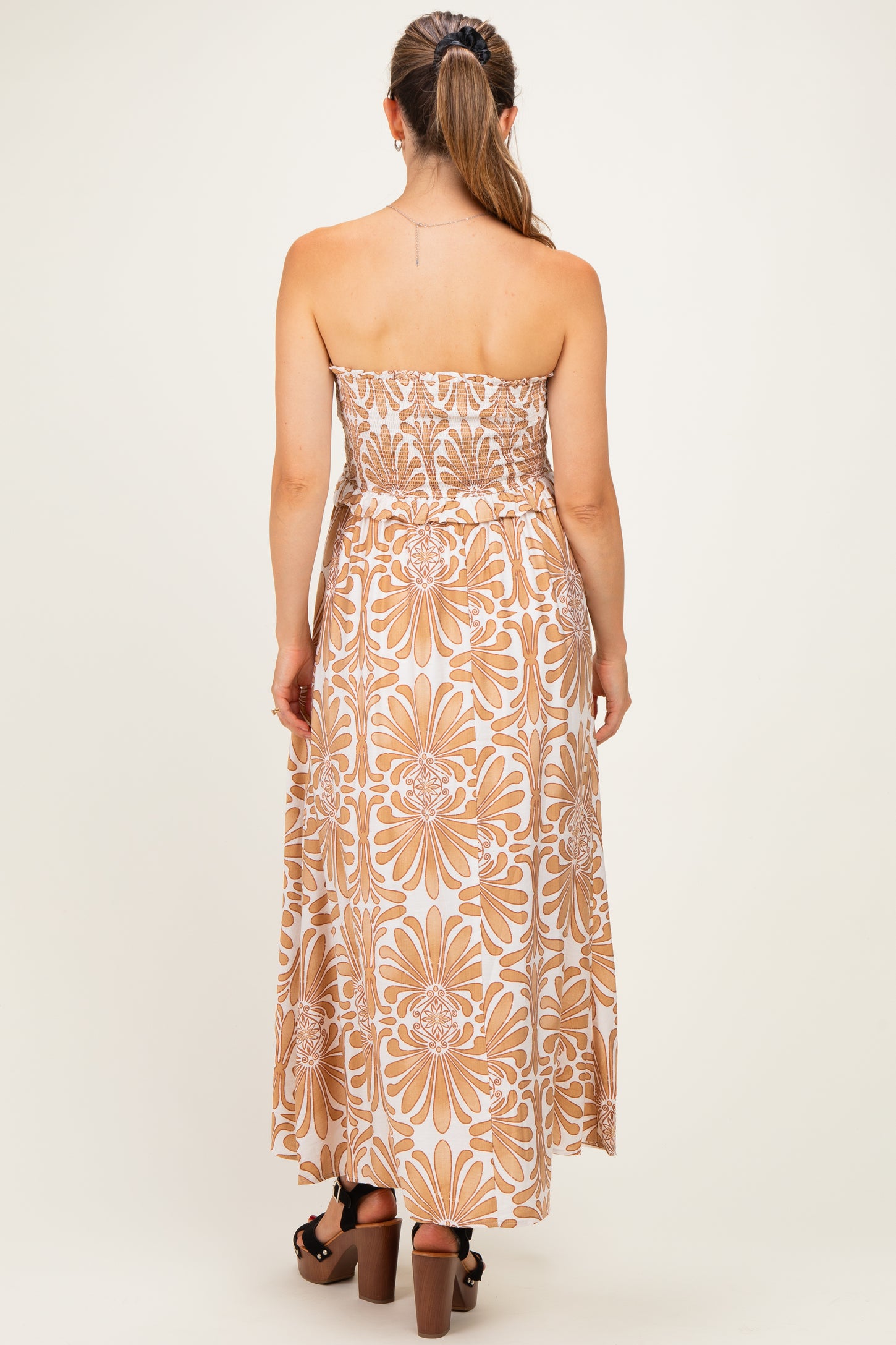 woman wearing a strapless floral print maternity maxi dress with a fitted bodice and flowy skirt