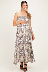 woman wearing a strapless floral maxi maternity dress and holding her baby bump