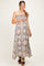 woman wearing a strapless floral maxi maternity dress and holding her baby bump