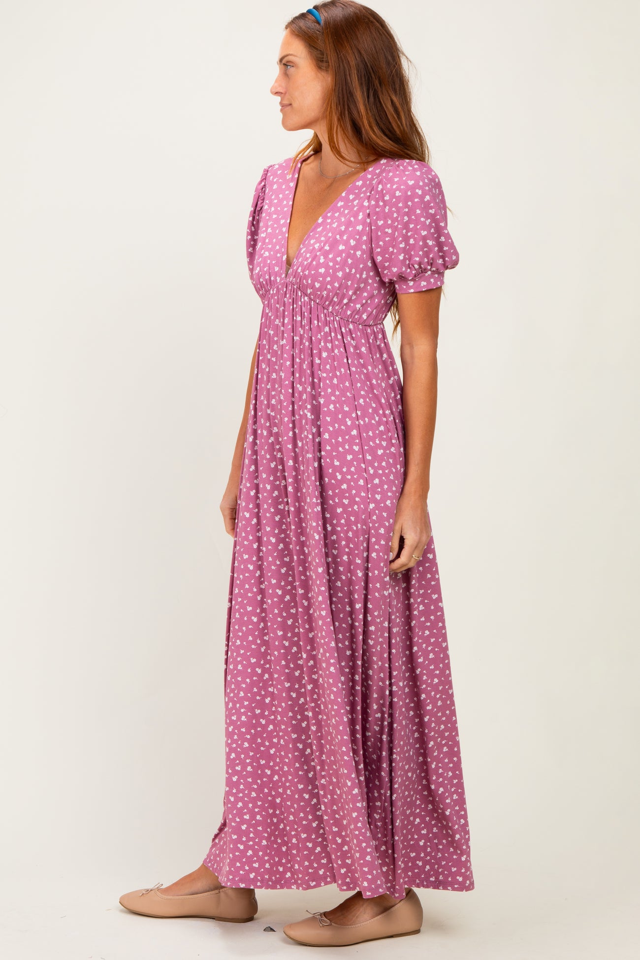 woman wearing a purple maxi dress with white polka dots and puff sleeves standing sideways