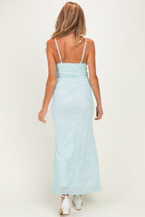 woman wearing a light blue floral maternity maxi dress with a fitted bodice and adjustable straps, showing a baby bump