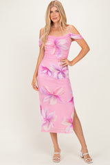 woman wearing a pink floral off-the-shoulder midi dress with side slit and fitted silhouette
