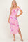 woman wearing a pink floral off-the-shoulder midi dress with side slit and fitted silhouette