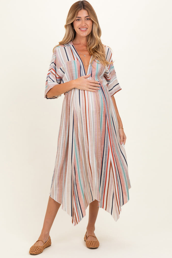 woman wearing a striped maternity maxi dress with a deep v-neck and holding her baby bump
