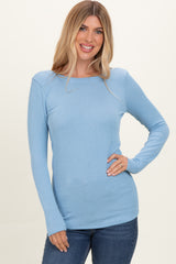 woman wearing a light blue ribbed long sleeve top paired with denim jeans