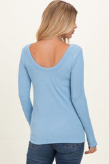 woman wearing a light blue ribbed long sleeve top with a scoop back, paired with dark jeans