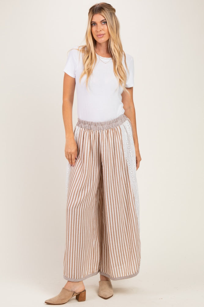 woman wearing a white short sleeve top and beige striped wide-leg pants with elastic waistband
