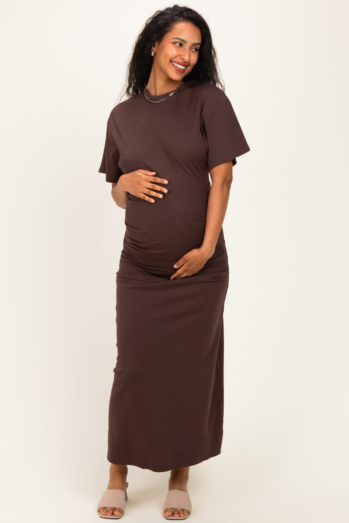 woman wearing a brown short sleeve maternity dress with a fitted silhouette and a visible baby bump
