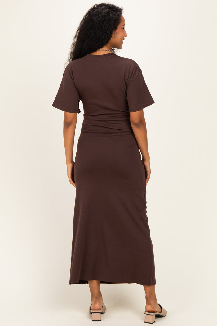 woman wearing a brown short sleeve maternity maxi dress, showing her back and flowing design