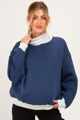 woman wearing a navy blue maternity sweatshirt with a gray funnel neck and relaxed fit