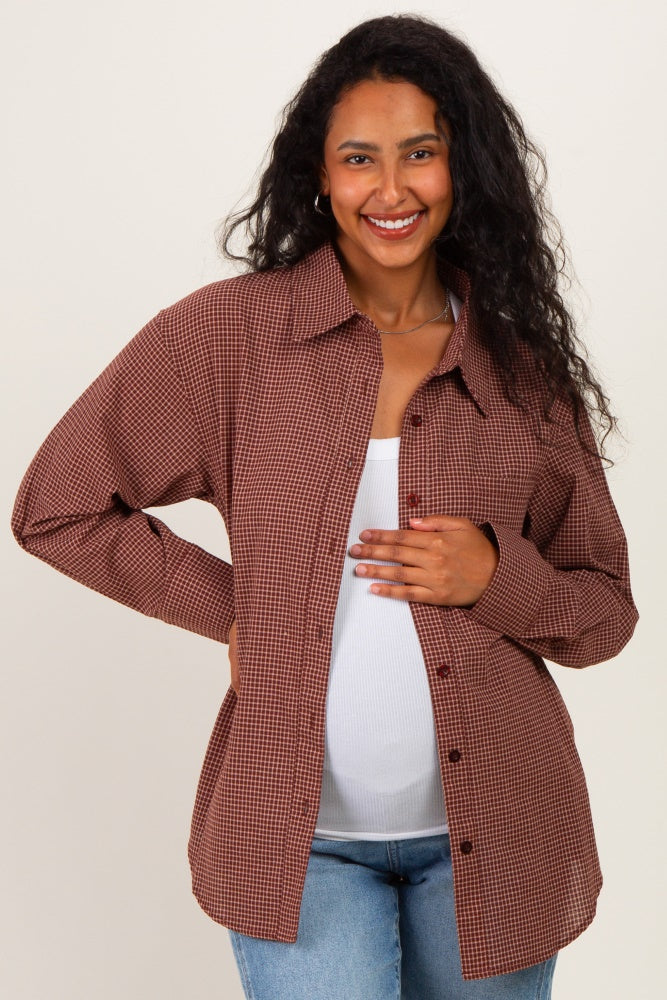woman wearing a brown checkered maternity button-up shirt and holding her baby bump