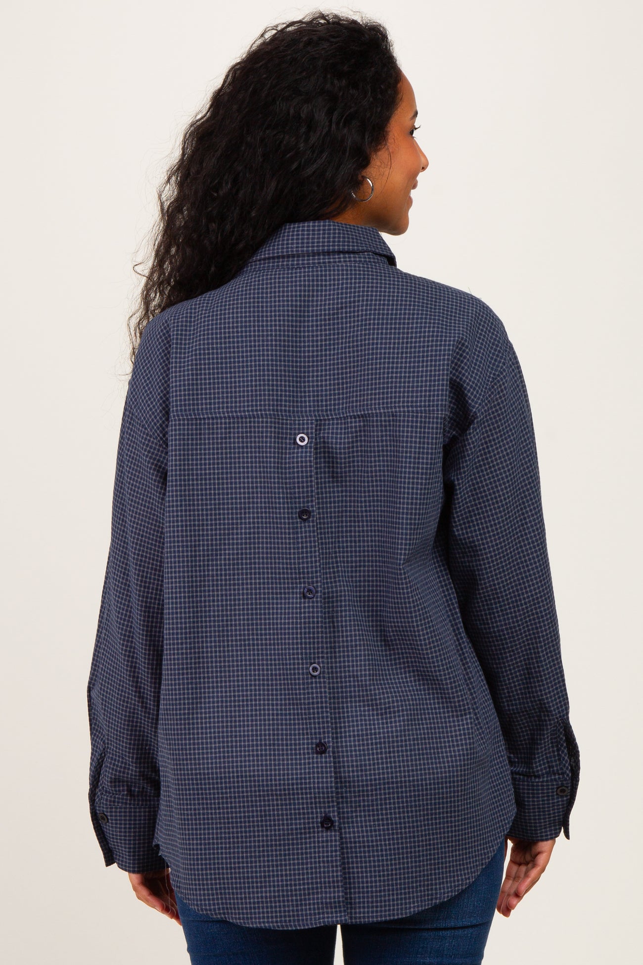 woman wearing a navy blue checked maternity shirt with a button-up back and long sleeves