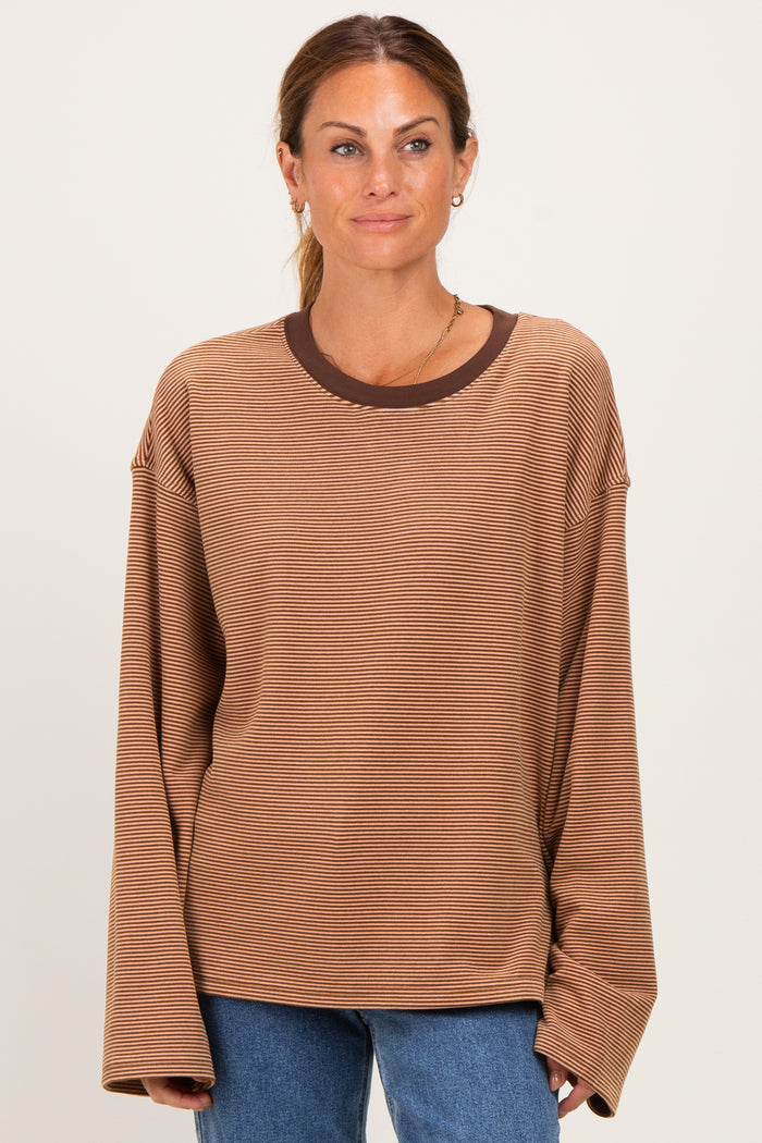 woman wearing a brown striped long sleeve top with a contrasting dark brown neckline and relaxed fit