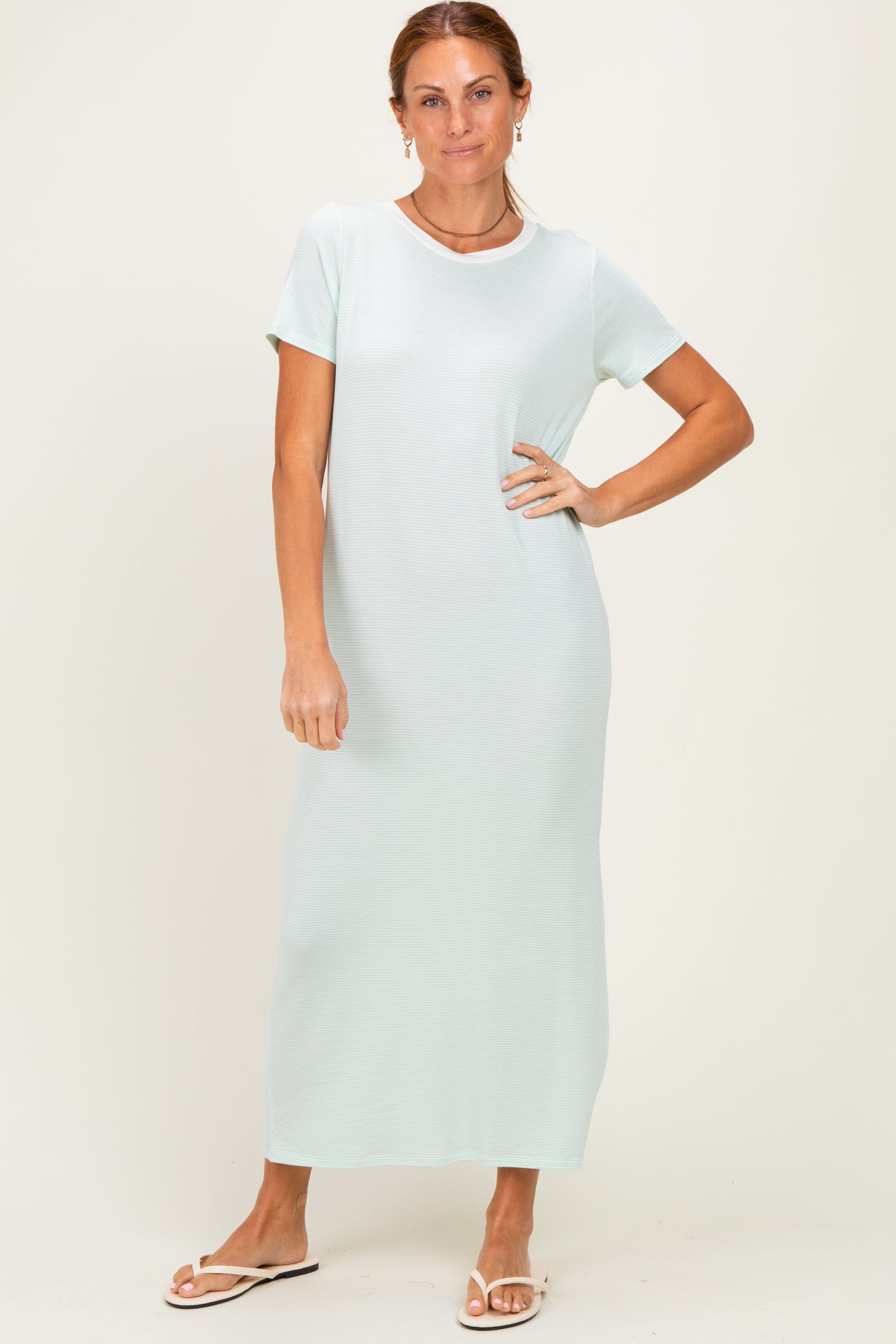 woman wearing a light mint green short sleeve maxi dress with a relaxed fit and round neckline