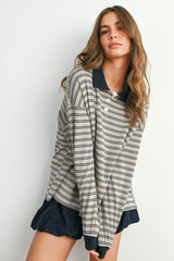 woman wearing a beige and navy striped long sleeve polo shirt with dark blue shorts