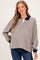 woman wearing a striped beige and navy maternity top with a collared neckline and relaxed fit