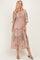 woman wearing a floral print maxi dress in muted pink with puff sleeves and tiered layers