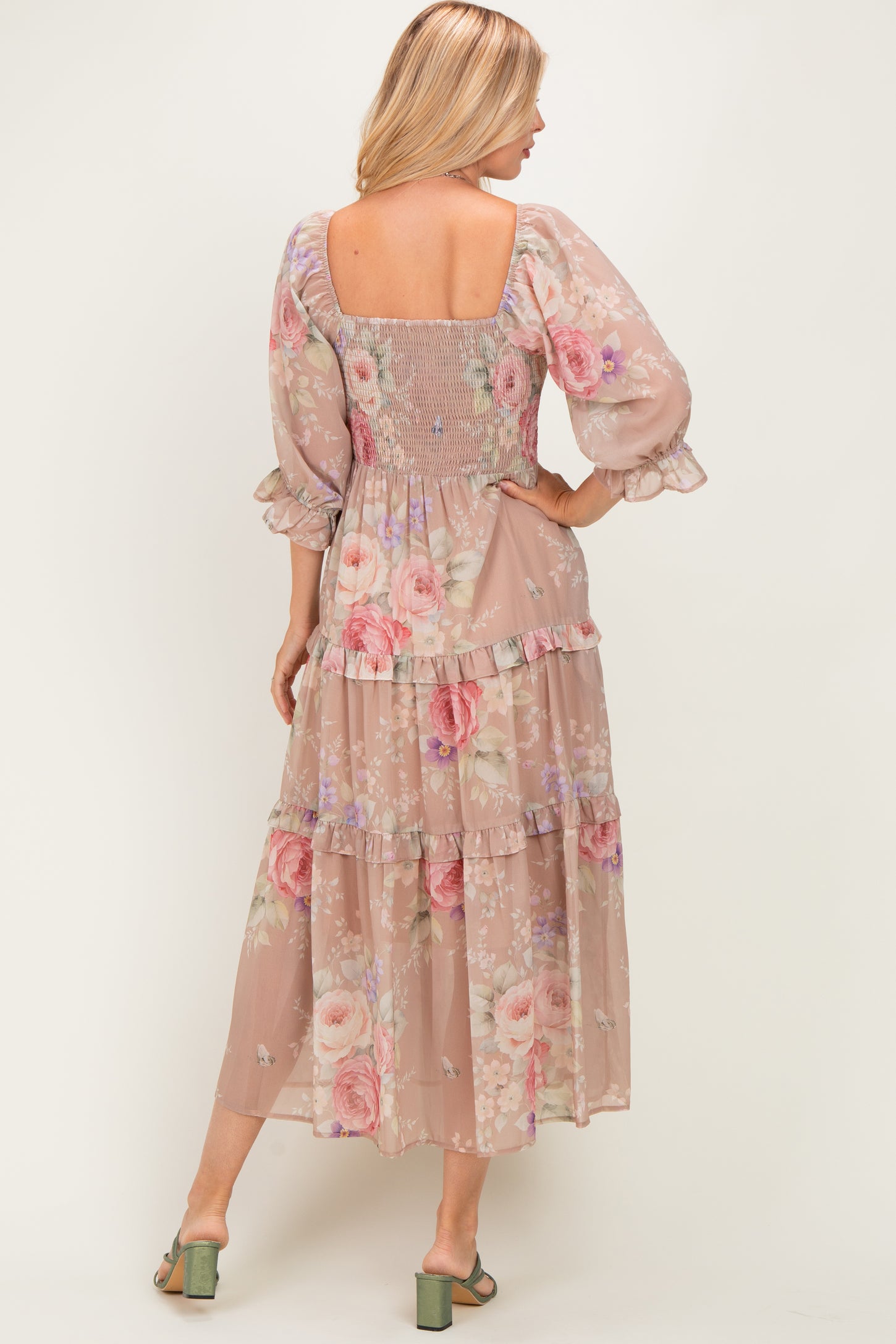 woman wearing a floral maxi dress with a square neckline and tiered ruffle detail, showing a smocked back and puff sleeves