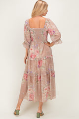woman wearing a floral maxi dress with a square neckline and tiered ruffle detail, showing a smocked back and puff sleeves