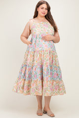 woman wearing a multicolored floral print maternity plus dress with tiered skirt and adjustable straps, showing her baby bump