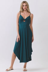 woman wearing a teal sleeveless maxi dress with a front twist detail and uneven hemline