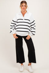 woman wearing a white and black striped maternity pullover with a collar and buttons, paired with black wide-leg pants