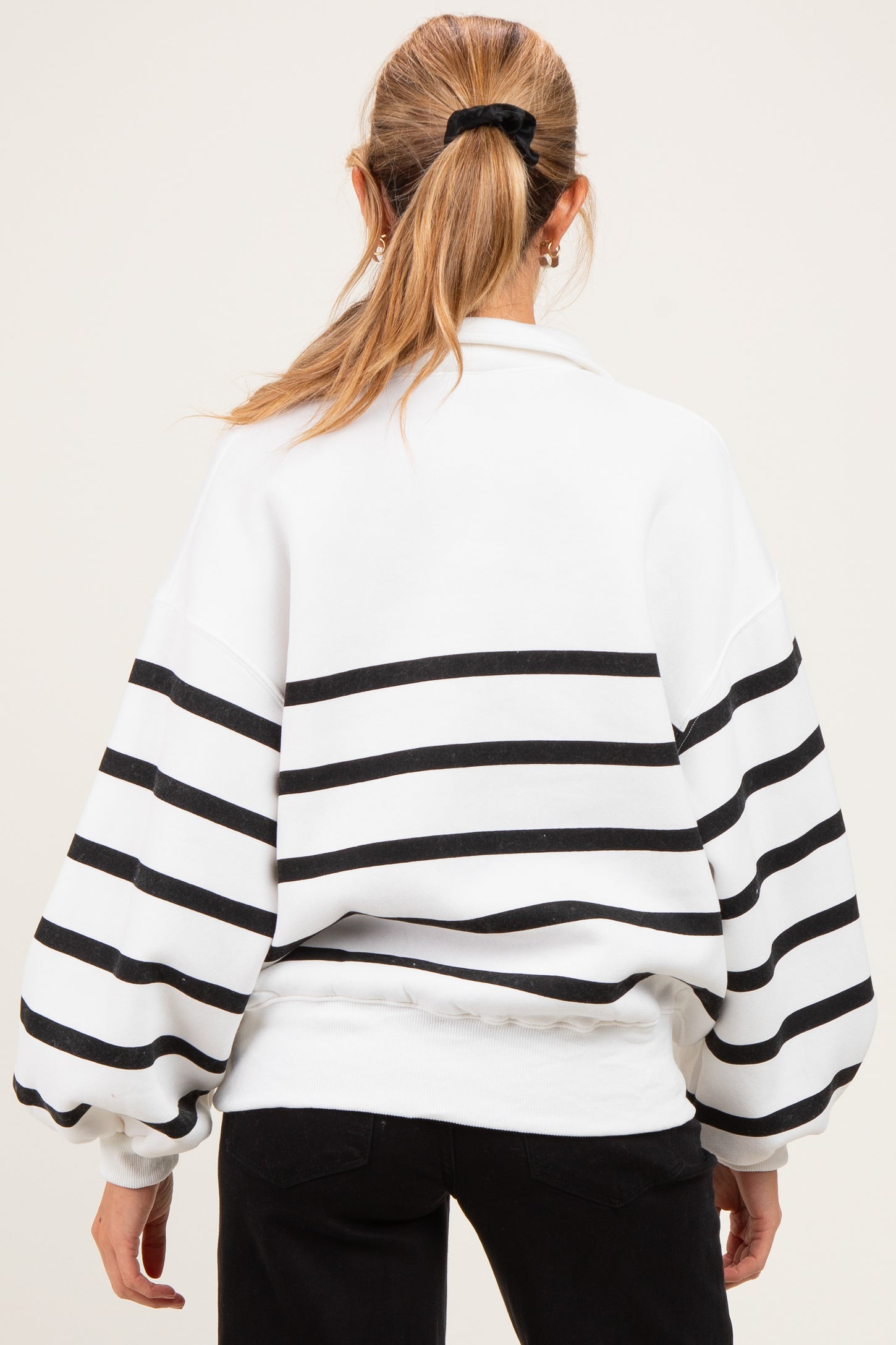 woman wearing a white and black striped maternity sweatshirt with a relaxed fit and balloon sleeves