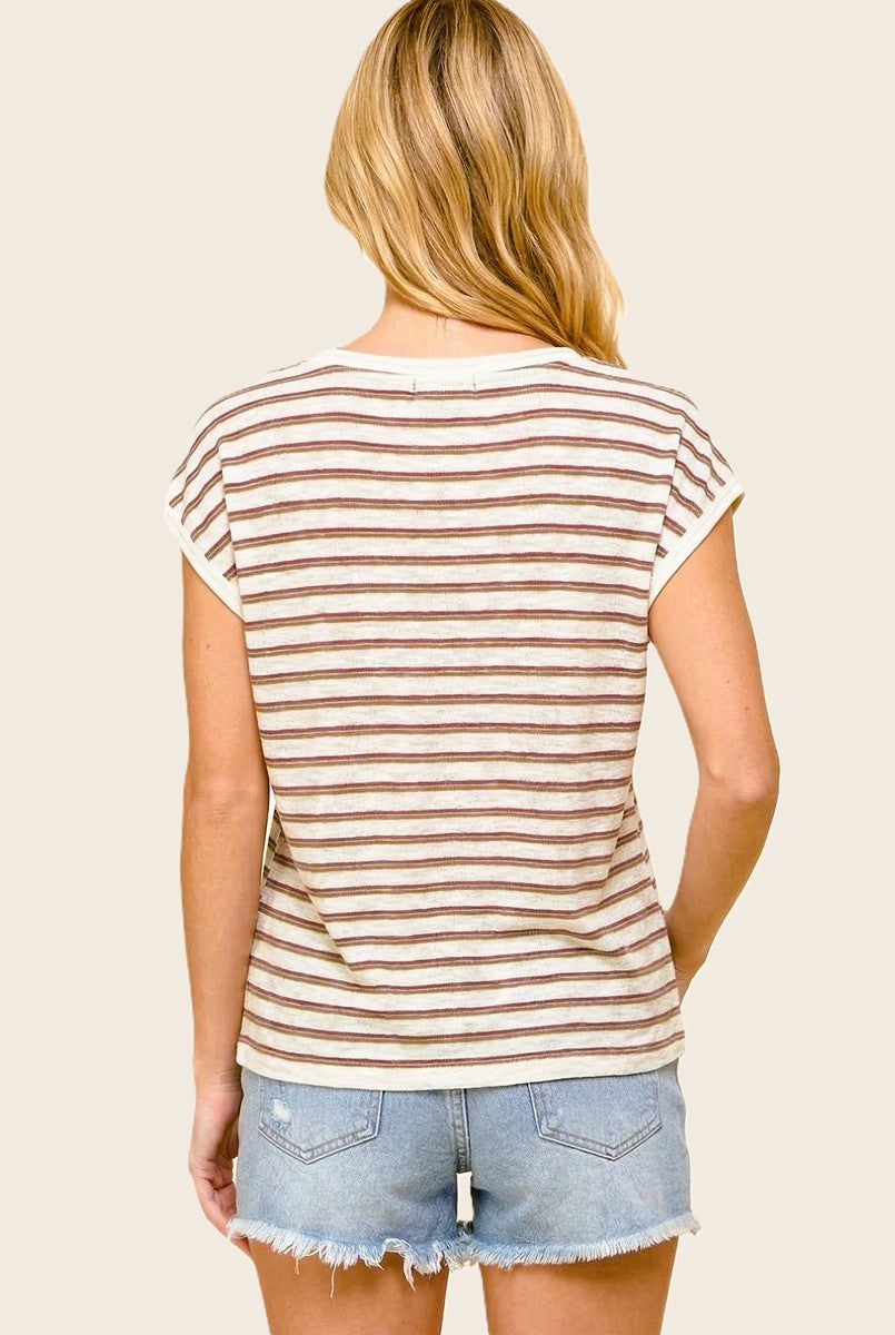 woman wearing a cream and brown striped short sleeve top paired with light blue denim shorts