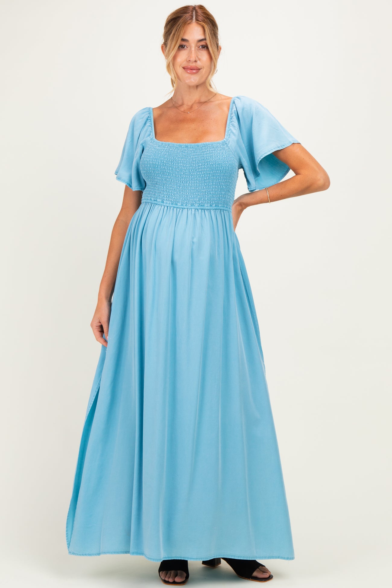 woman wearing a light blue maternity maxi dress with a square neckline and short puff sleeves