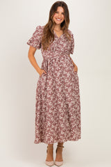 woman wearing a mauve floral print maternity maxi dress with short sleeves and pockets