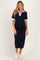 woman wearing a navy blue maternity dress with a collar and short sleeves, showcasing her baby bump