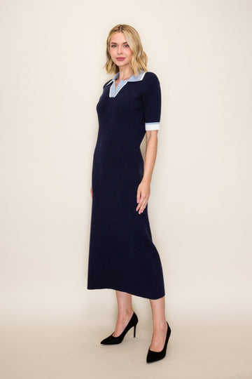 woman wearing a navy blue knitted midi dress with a light blue collar and short white sleeves, paired with black heels