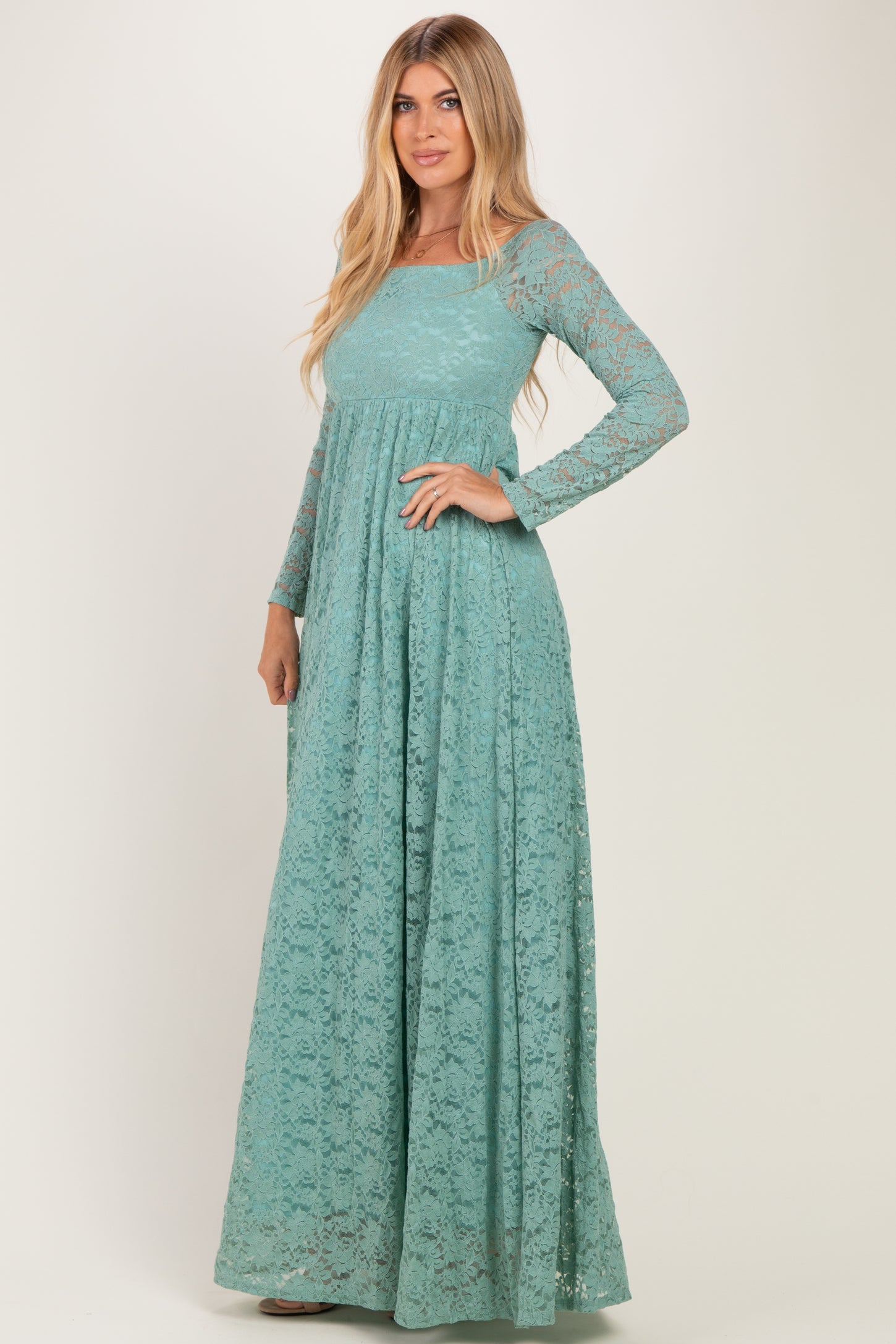 woman wearing a teal long sleeve lace maxi dress with a fitted bodice and flowing skirt