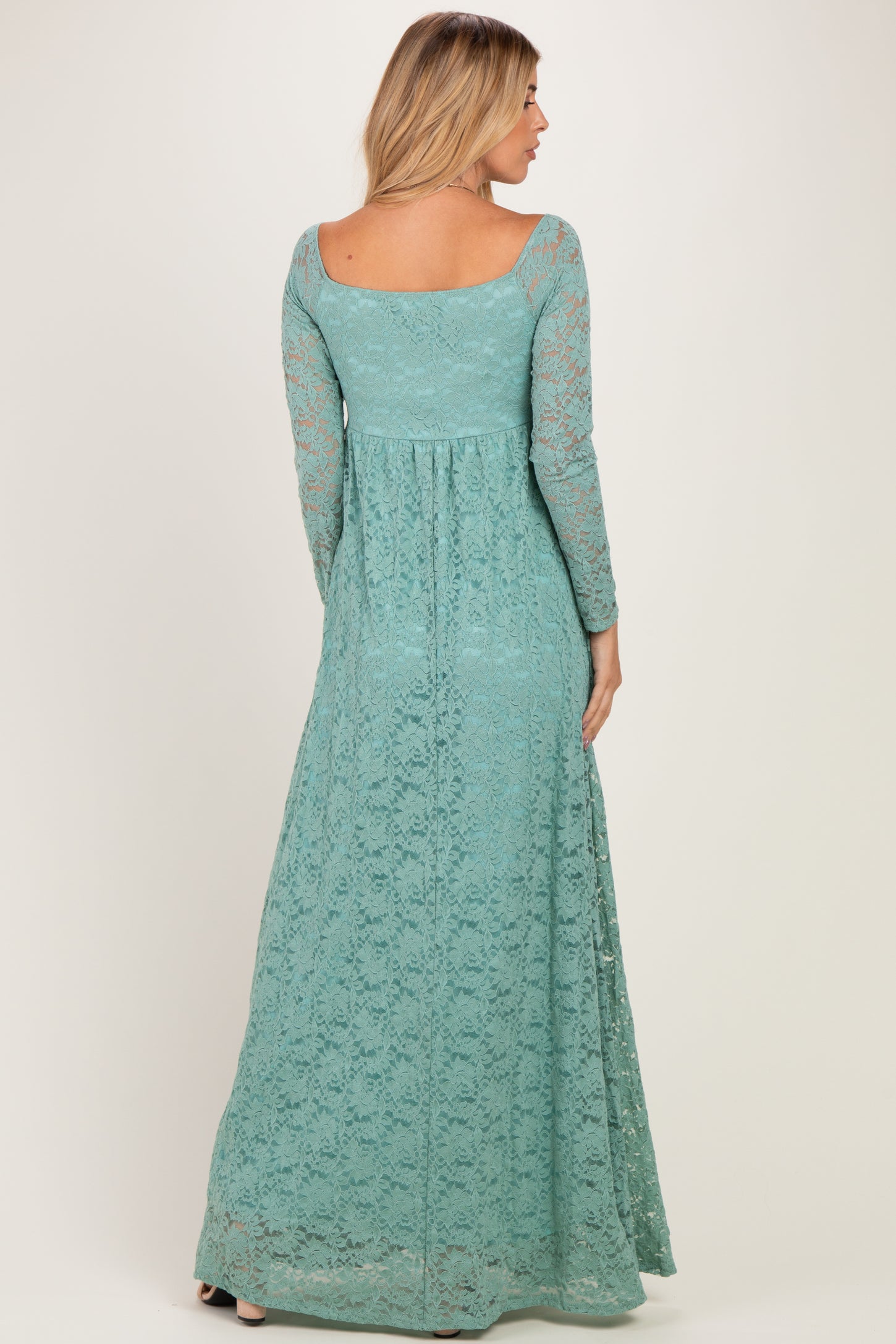 woman wearing a long teal lace maxi dress with long sleeves and a fitted waist, showing the back view