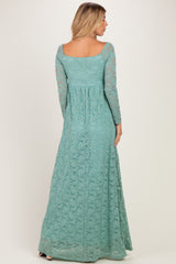 woman wearing a long teal lace maxi dress with long sleeves and a fitted waist, showing the back view