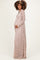 woman wearing a long sleeve pink lace maternity gown and holding her baby bump
