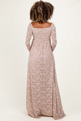 woman wearing a blush pink long sleeve lace maternity dress with a flowing skirt and off-shoulder neckline