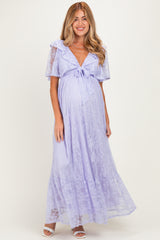 woman wearing a lavender lace maternity maxi dress with a tie front and flutter sleeves, showing her baby bump