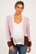 woman wearing a light pink and brown color block maternity cardigan over a white top and showing her baby bump