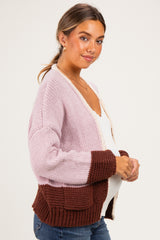 woman wearing a color block maternity cardigan in pink and brown with a visible baby bump